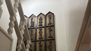 Una escala amb un panell decoratiu a la paret que representa diverses figures.
