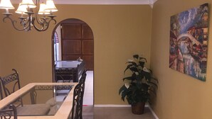 A dining area with a table and chairs, a chandelier, a potted plant, and a painting on the wall. - Super Bowl Head Quarter,NRG,Minute Maid,Convention,MedCenter,MdAnderson,Galleria (Houston)