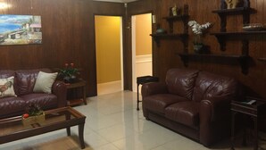 A living room with two leather sofas, a coffee table, and wooden shelves with decorative items. - Super Bowl Head Quarter,NRG,Minute Maid,Convention,MedCenter,MdAnderson,Galleria (Houston)