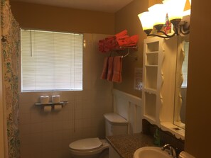 Ein Badezimmer mit Toilette, Waschbecken und einem Handtuchhalter mit gefalteten Handtüchern.