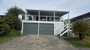 A two-story building with a covered upper level and a ground-level garage. - 63 Vista Drive, Mallacoota (Mallacoota)