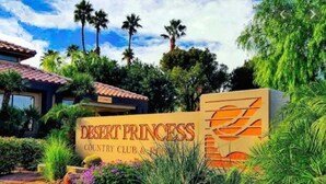 A sign for Desert Princess Country Club & Resort with a clear view of the surrounding greenery and palm trees. - Beautiful Desert Princess Resort Condo Awesome Views of Golf Course & Mountains  (Cathedral City)