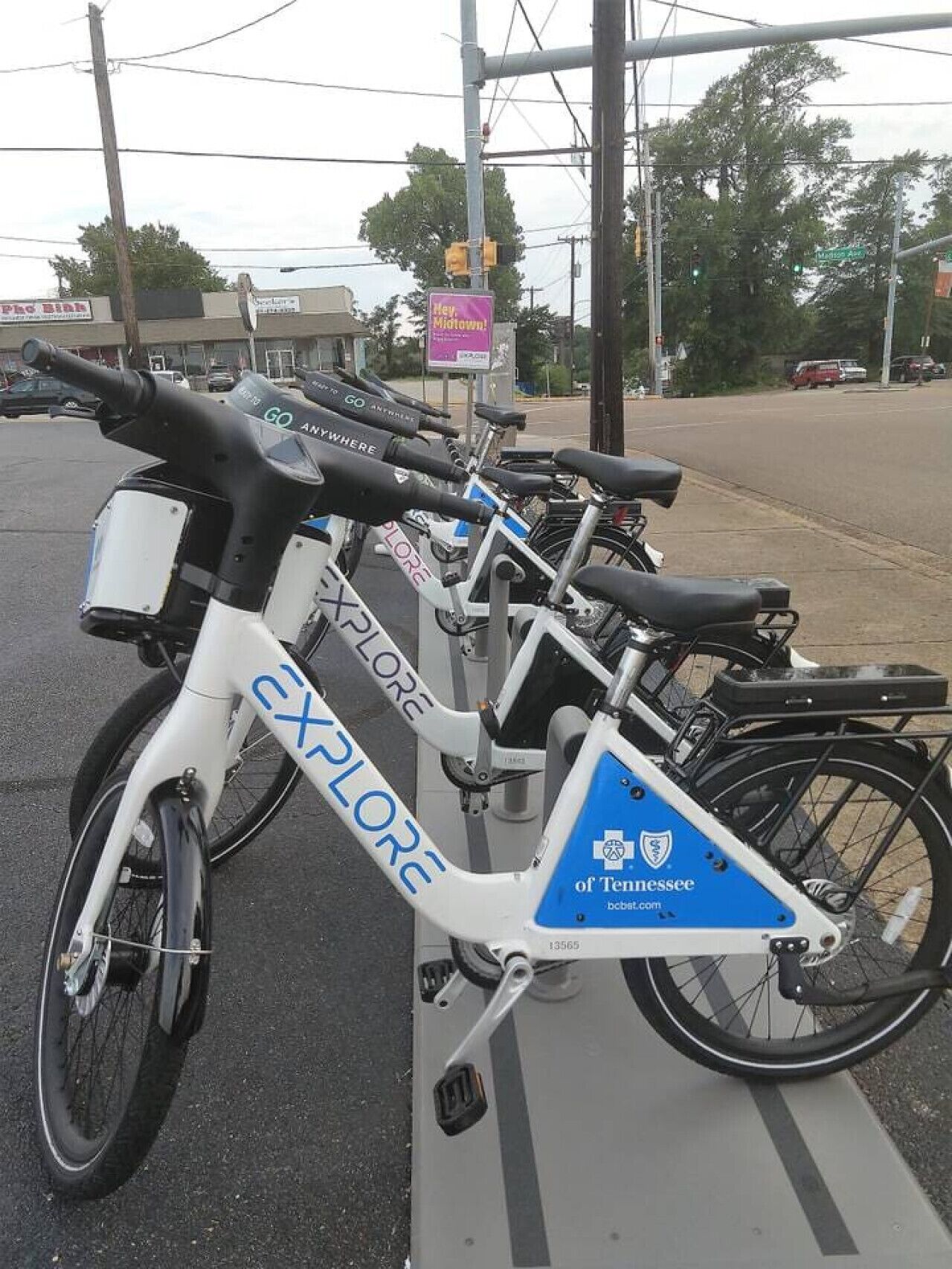 Une rangée de vélos portant la marque « EXPLORE », garés sur un trottoir.
