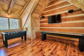 A wooden-floored room with a foosball table and a pool table. - Wildcat Lodge - Luxury Accommodations (Rockbridge)