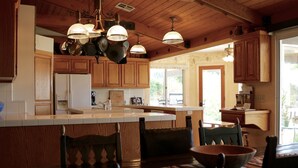 A kitchen with wooden cabinets, a central island, and pendant lighting. - Enjoy the RANCHO Villa Heart of Temecula Wine Country Golf Casinos Views RVC-023 (Temecula)