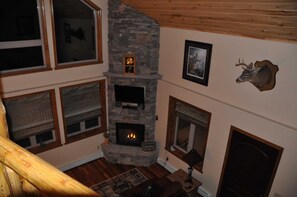 Cozy space with a stone fireplace, framed picture, and wooden features.