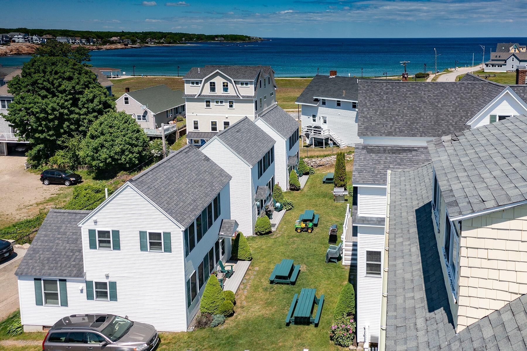 A residential area with houses, a lawn, and a view of the ocean.