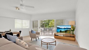 Relax in this spacious living area with a large flat-screen TV, comfortable sofa, and dining space.