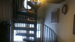 A staircase with a light fixture at the top, a couch, and a fireplace. - Rickett's Glen state Park!  Our cabin is only 1/2mile from the trail head. (Benton)