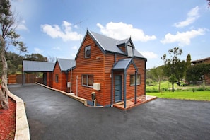 A two-story wooden building with a flat roof and a paved driveway.