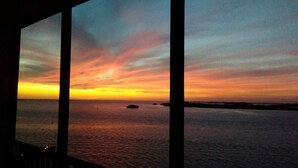 A view of the ocean at sunset with a clear horizon and distant landforms. - Sanibel Harbour Resort - Panoramic Beachfront Luxury 2/2 Condo! (Fort Myers)