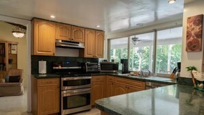 Una cocina moderna con armarios de madera, electrodomésticos de acero inoxidable y una isla grande.