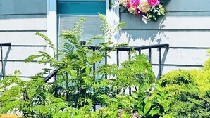 A house with a teal door, a number '21' sign, a lantern, and a wreath with flowers. -  Beautiful Waterfront Home (Misquamicut)