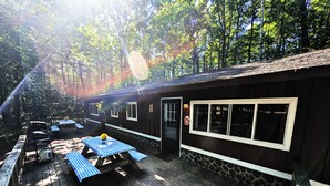 A cabin with a deck, picnic tables, and a barbecue grill. - Amenities & Resort Access Included, Cabin 4 (Phelps)
