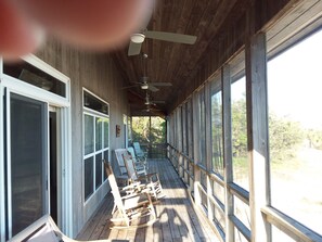 Relax on the porch with a view, surrounded by comfortable seating and ceiling fans.