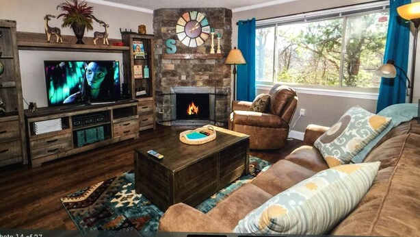 A cozy living room with a fireplace, a television, and a comfortable sofa.