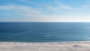 Una playa con cielo despejado y mar tranquilo.