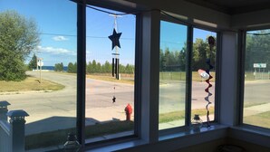 Ett rum med stora fönster som vetter ut mot en parkeringsplats, ett rött brandhydrant och en stjärnformad dekoration.