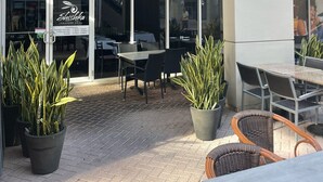 Una parrilla libanesa con mesas al aire libre y plantas en macetas.