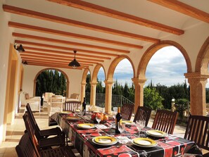 An outdoor dining area with a covered pergola, stone arches, and a view of the surrounding greenery. - Villa with private pool in Javea, Costa Blanca, Alicante. 5 bedrommsA/C. WiFi (Javea)