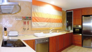 Une cuisine moderne avec des meubles en bois, des appareils en acier inoxydable et un espace repas aménagé sur le comptoir.