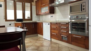 A kitchen with wooden cabinets, a dishwasher, a microwave, and an oven.