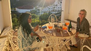 A balcony with a table set for two, overlooking a hillside village. - Large Four bedroom house in exquisite 16th century Moorish village. Sleeps 8. (Frigiliana, Nerja)