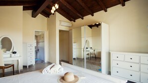 A bedroom with a large bed, a desk, a chair, a mirror, and a wardrobe. - Beautiful Villa Layla with pool (Castiadas)