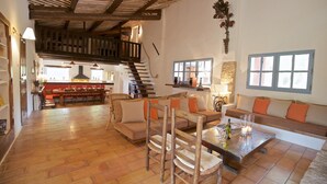 A spacious living area with a wooden floor, a sofa set, a coffee table, and a staircase leading to an upper level. - Beautifully renovated Artist’s farmhouse in Provence, large heated pool & sauna (Roussillon)