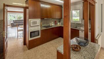 Een koelkast, een magnetron, een oven, kookgerei, borden en bestek