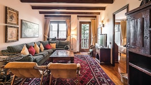 Un salon confortable avec un canapé, des fauteuils, une table basse et un téléviseur.