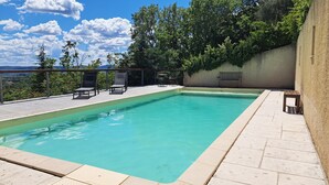 A rectangular swimming pool with a tiled deck, surrounded by lounge chairs and a table. - Lovely Family Home With Pool, Complete Privacy And Views Over The Lubero  (Forcalquier)