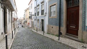 Una calle adoquinada flanqueada por edificios coloridos, cada uno con estilos arquitectónicos distintos y azulejos decorativos.