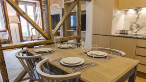 Comedor con una mesa de madera dispuesta para cuatro personas, rodeado de sillas.