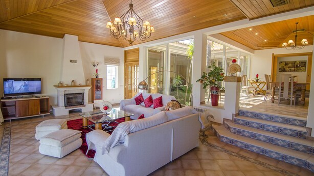 A spacious living room with a fireplace, a television, and a sofa. - Villa Lira | 6 bedrooms | Spacious | Quinta do Lago (Quinta do Lago)