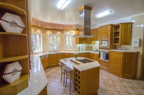 A kitchen with wooden cabinets, a central island, and a built-in oven.