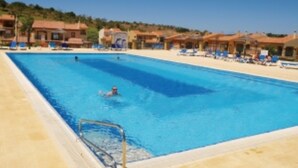 Piscina com espreguiçadeiras e posto de salva-vidas.