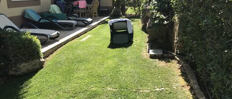 Un césped cuidado con un vehículo verde pequeño estacionado en el centro.