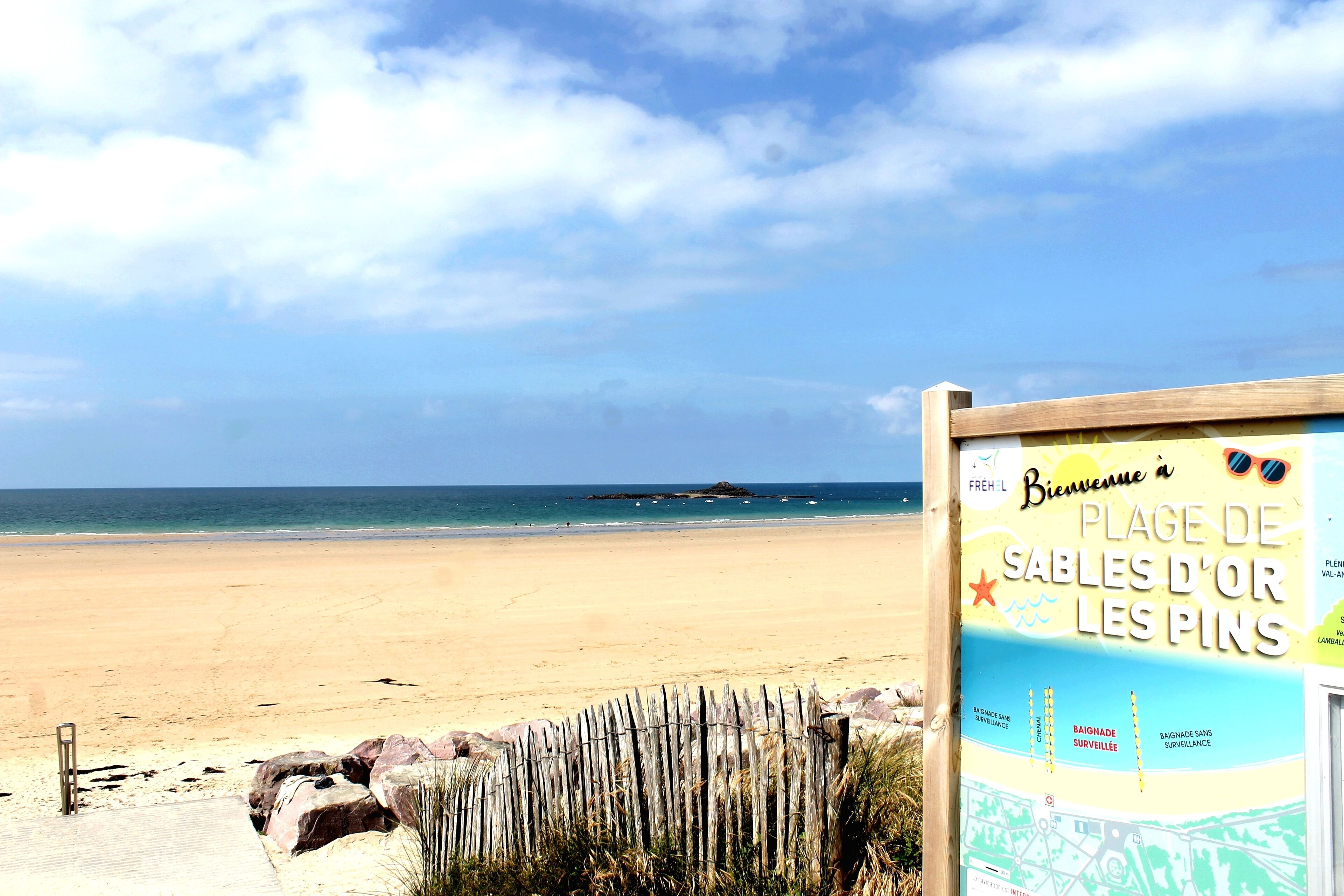 Een strand met een bord waarop 'Place de Sables d'Or Les Pins' staat.