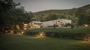 A modern house with a large patio area, a stone wall, and a grassy yard. - Large Holiday House in the Alto Minho- Vila nova de Cerveira - Max. 17 people (Vila Nova de Cerveira)