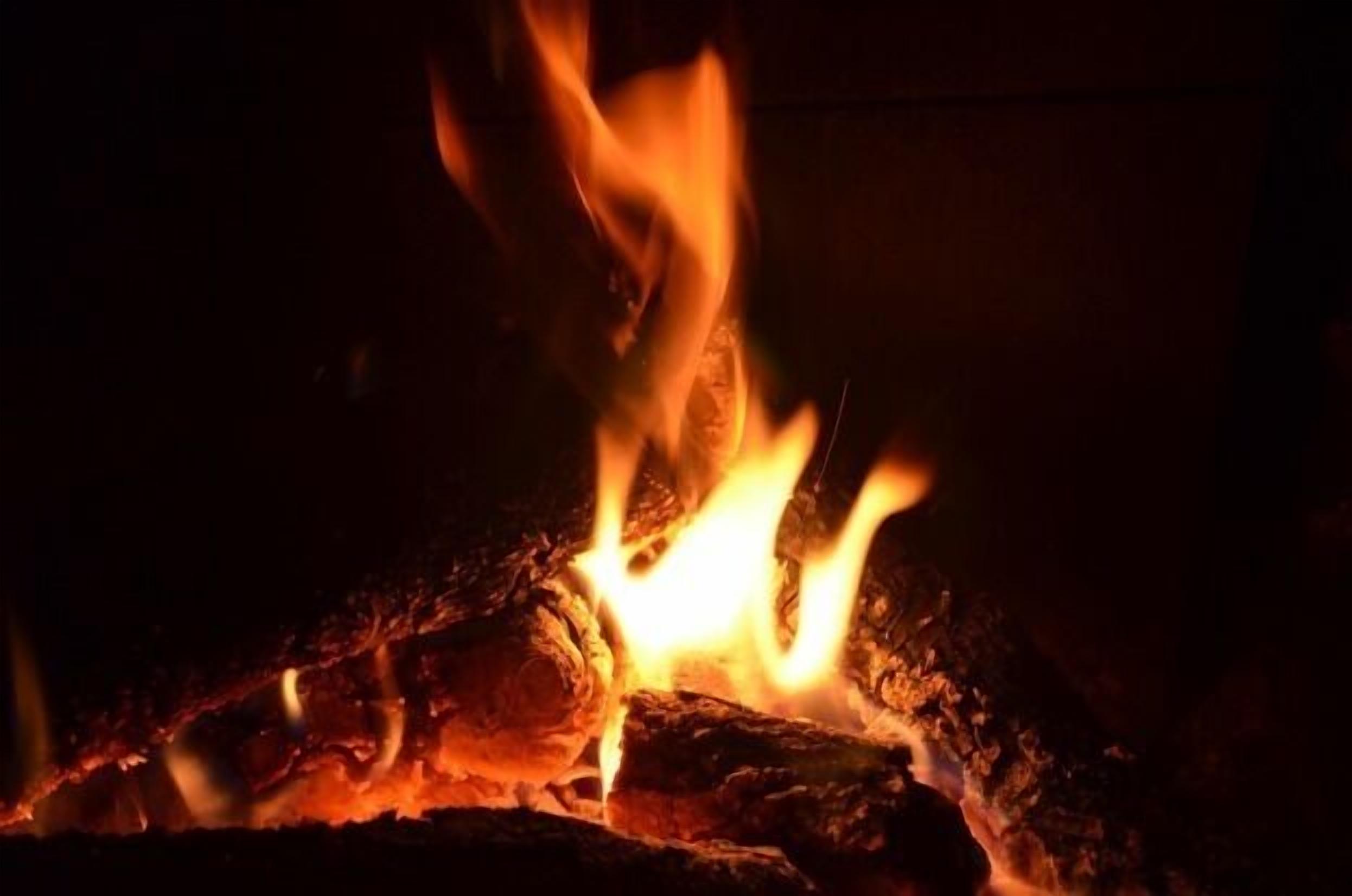 A close-up of burning wood, likely part of a fireplace or bonfire.