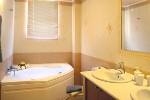 Ein Badezimmer mit Badewanne, Waschbecken und Spiegel.
