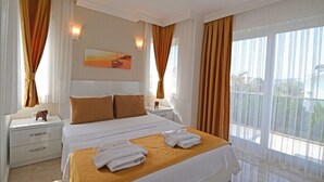 Habitación de hotel con una cama grande, dos mesitas de noche, una lámpara, una ventana con cortinas y un cuadro en la pared.