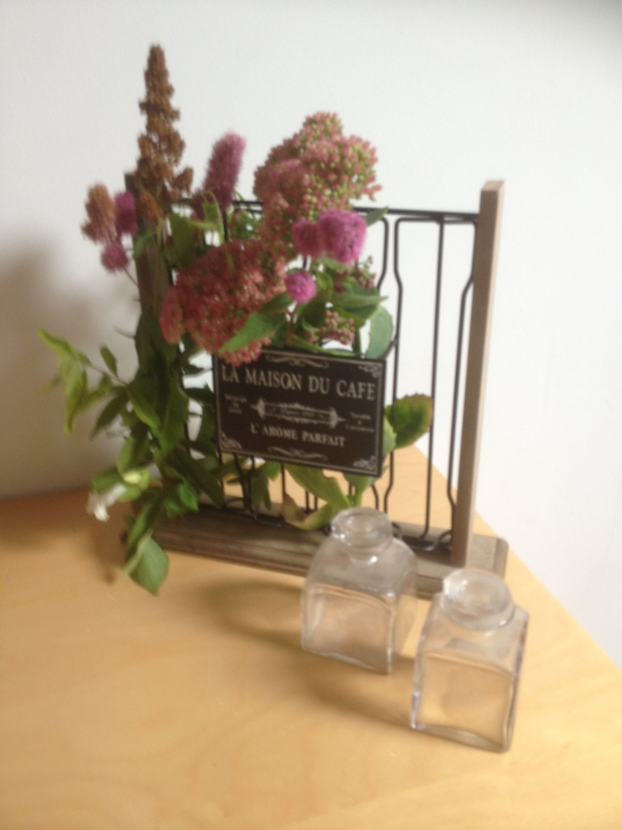 A table with a sign reading "La Maison du Cafe" and two salt shakers.