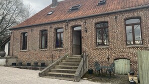 A brick building with a tiled roof, a front door, and a set of stairs leading to the entrance. - Lovely Former Bakery In The Seven Valleys (Embry)