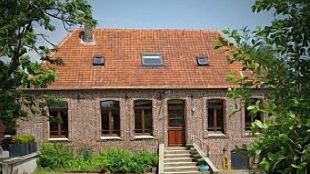 A two-story house with a brick facade, a tiled roof, and a front entrance with a staircase leading to the door. - Lovely Former Bakery In The Seven Valleys (Embry)