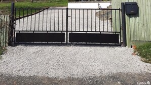 A gated entrance to a property with a gravel driveway, a brick building, and bare trees. - Lovely Former Bakery In The Seven Valleys (Embry)