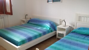 A twin room with two beds, each with a nightstand and a lamp.
