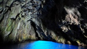 A cave with a blue-lit water pool.