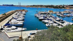 A marina with numerous boats docked, a clear blue sky, and a distant cityscape. - Beautiful apartment with private pool, wifi, tv, close to all amenities (Orihuela Costa)